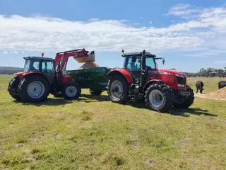 Two Massey Ferguson tractors loading a fertiliser spreader