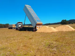 Truck unloading material on a property