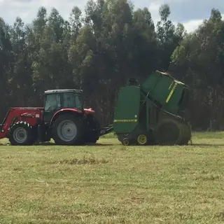 Tractor and round baler at work